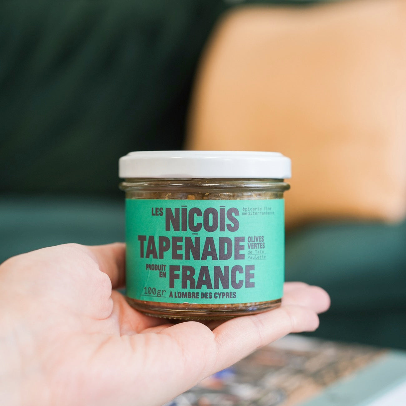 Pot de tapenade verte avec olives, texture lisse et crémeuse.