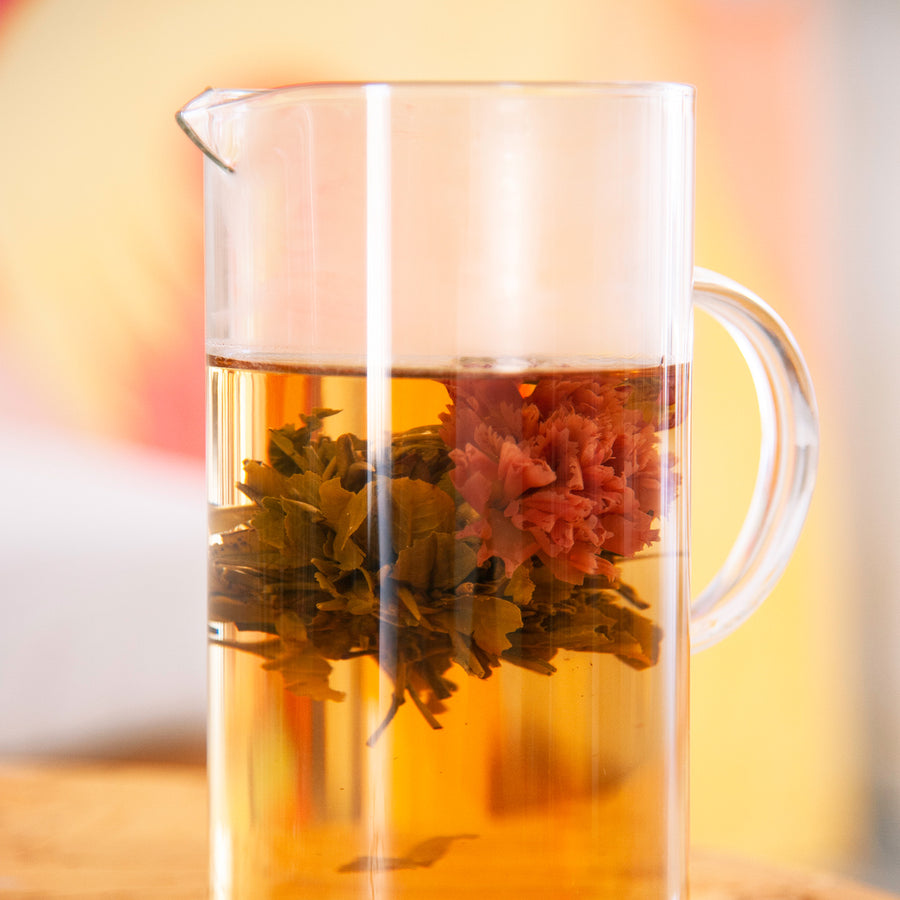 Fleur de thé de pivoine en éclosion dans l'eau chaude