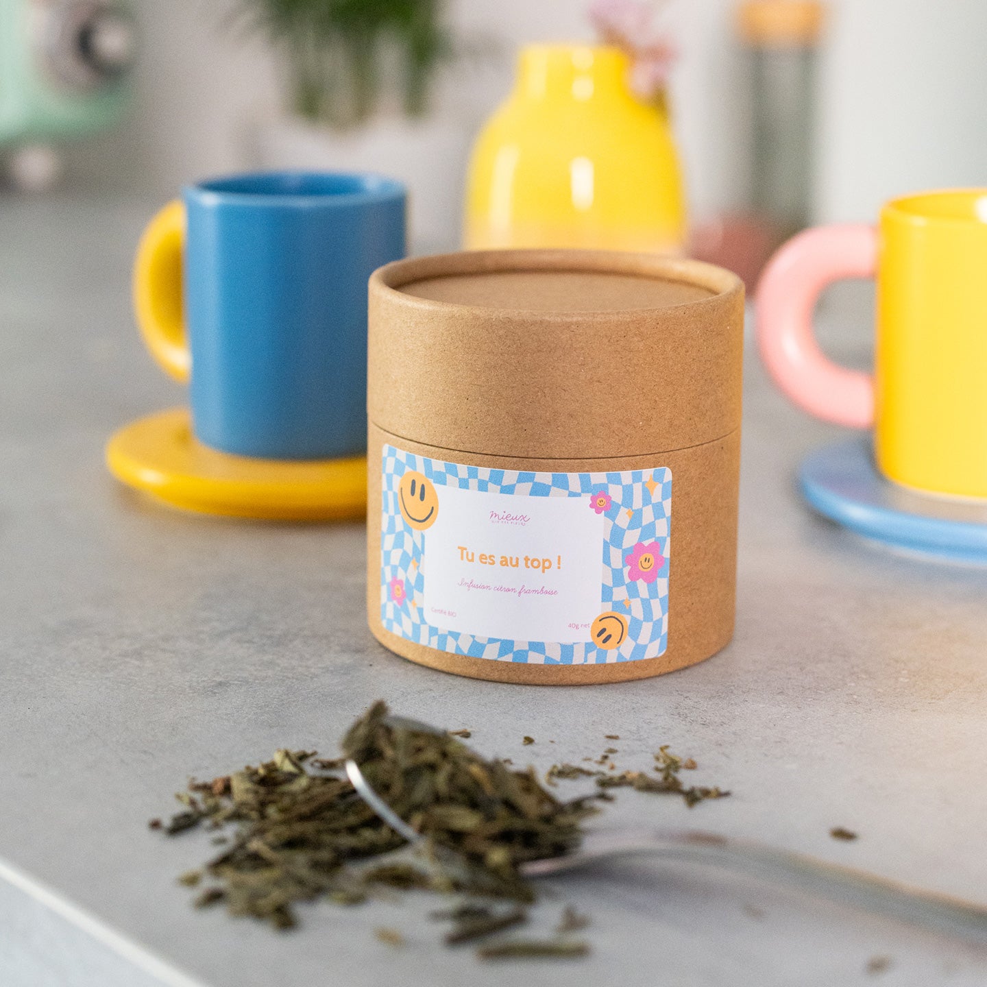 Boîte de thé avec message, vue de face et étiquette colorée.