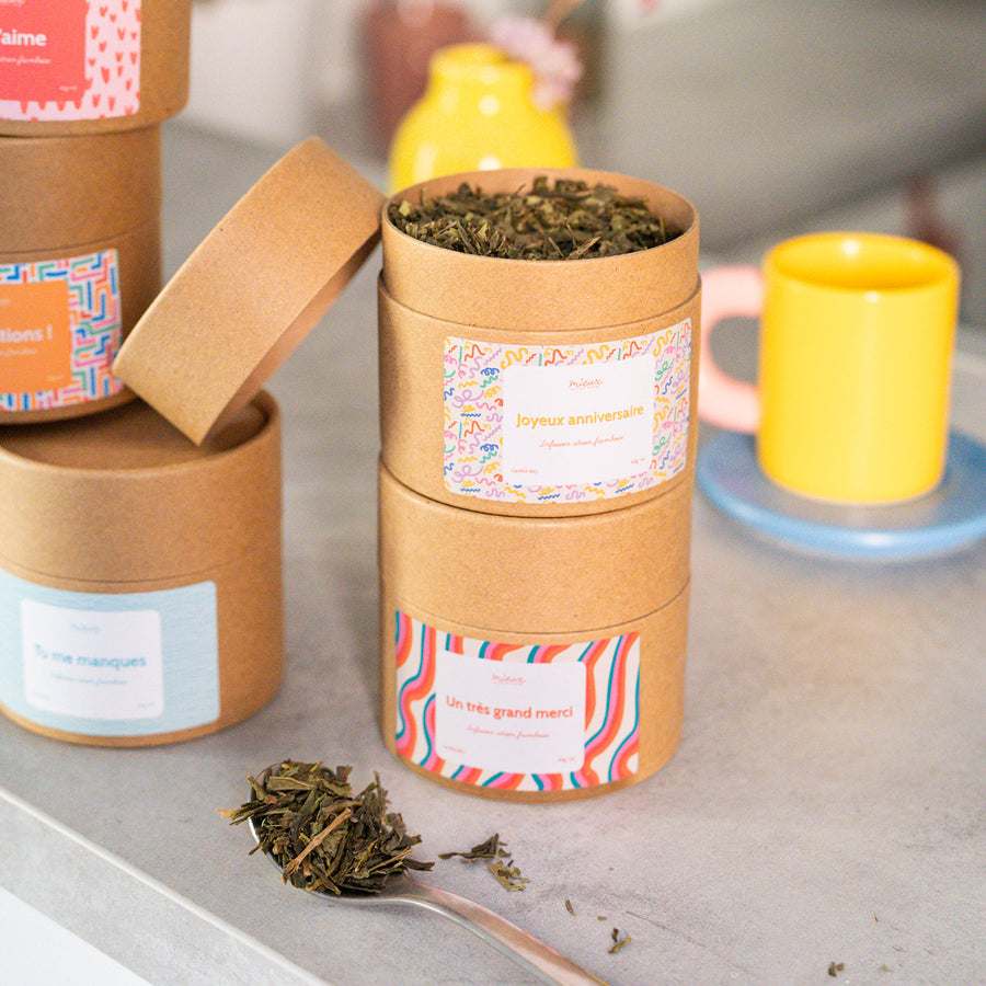 Boîte de thé avec message, vue de face et étiquette colorée.