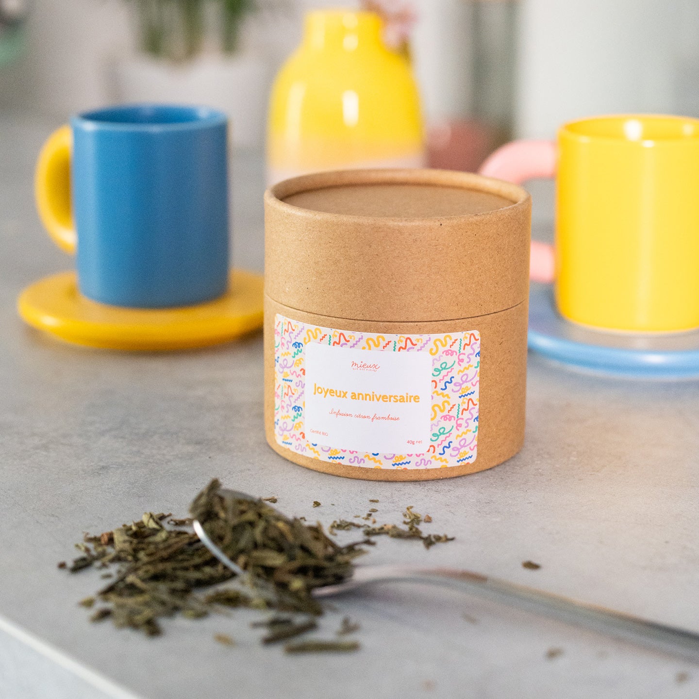 Boîte de thé avec message, vue de face et étiquette colorée.