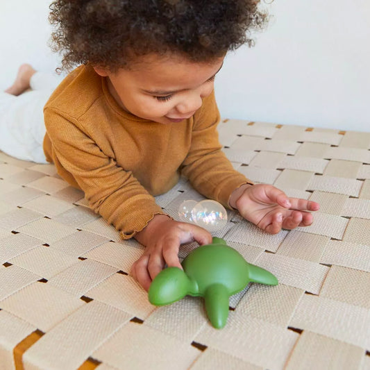Tortue de bain en filets recyclés, vue de côté avec texture détaillée.
