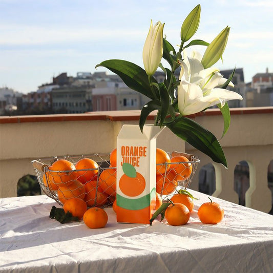 Vase en forme de brique de jus d'orange, vue de face.