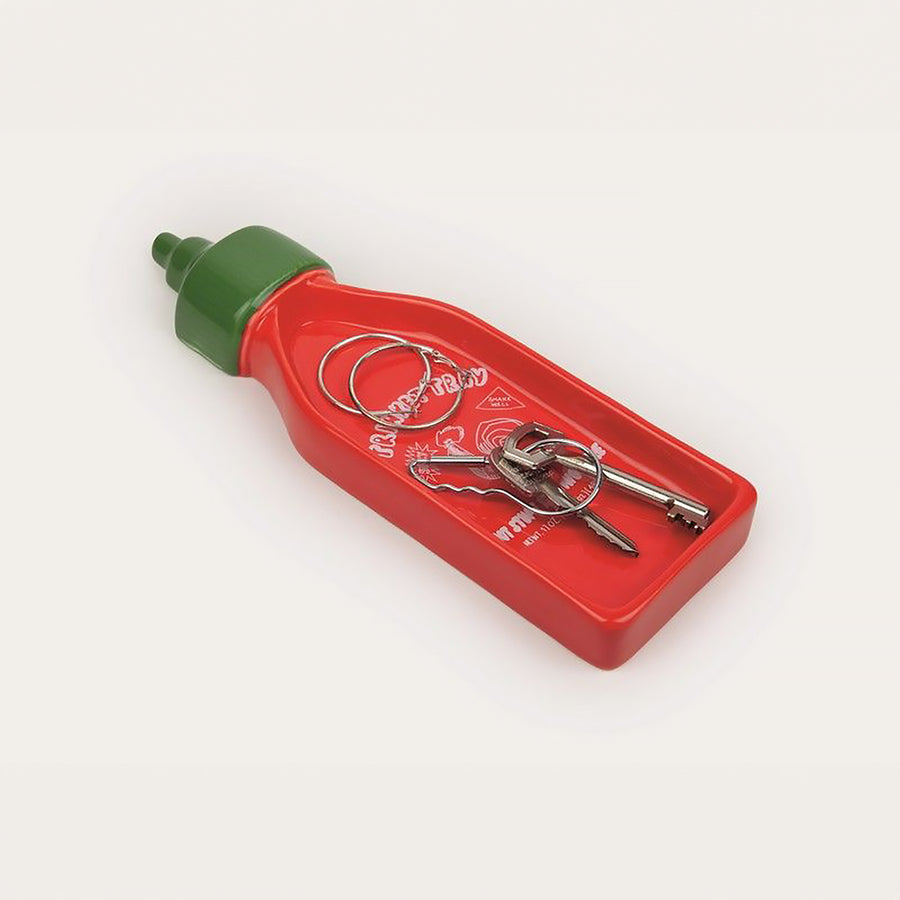 Vide-poche en forme de bouteille Sriracha avec détails colorés.