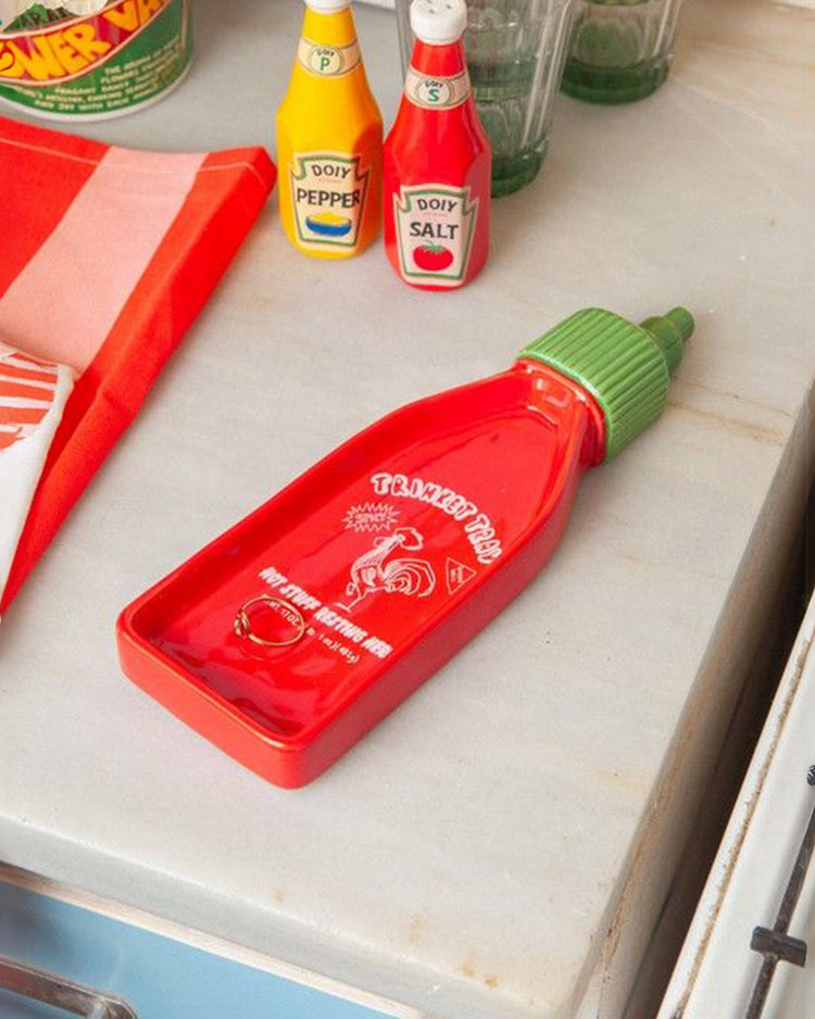 Vide-poche en forme de bouteille Sriracha avec détails colorés.