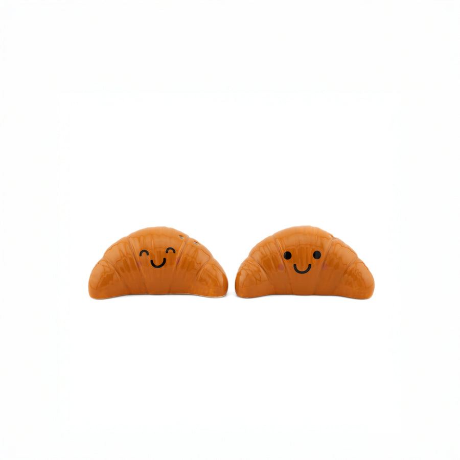 Salière et poivrière en forme de croissants sur fond clair