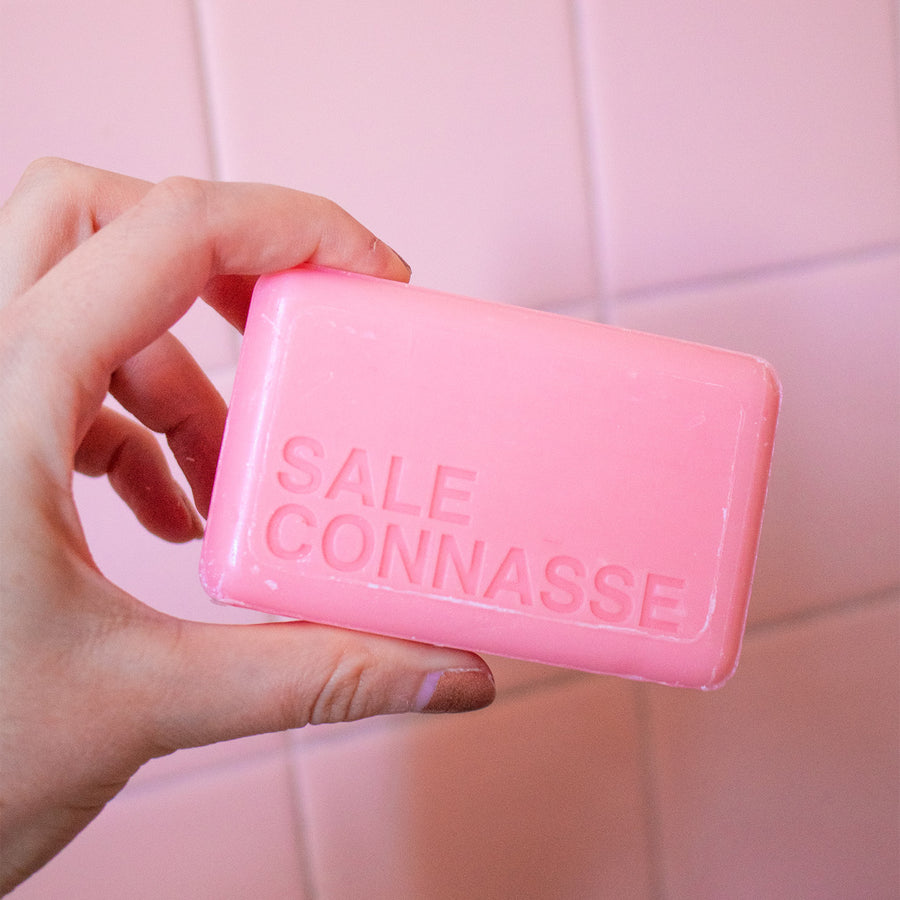 Savon humoristique avec étiquette colorée et motif rose.