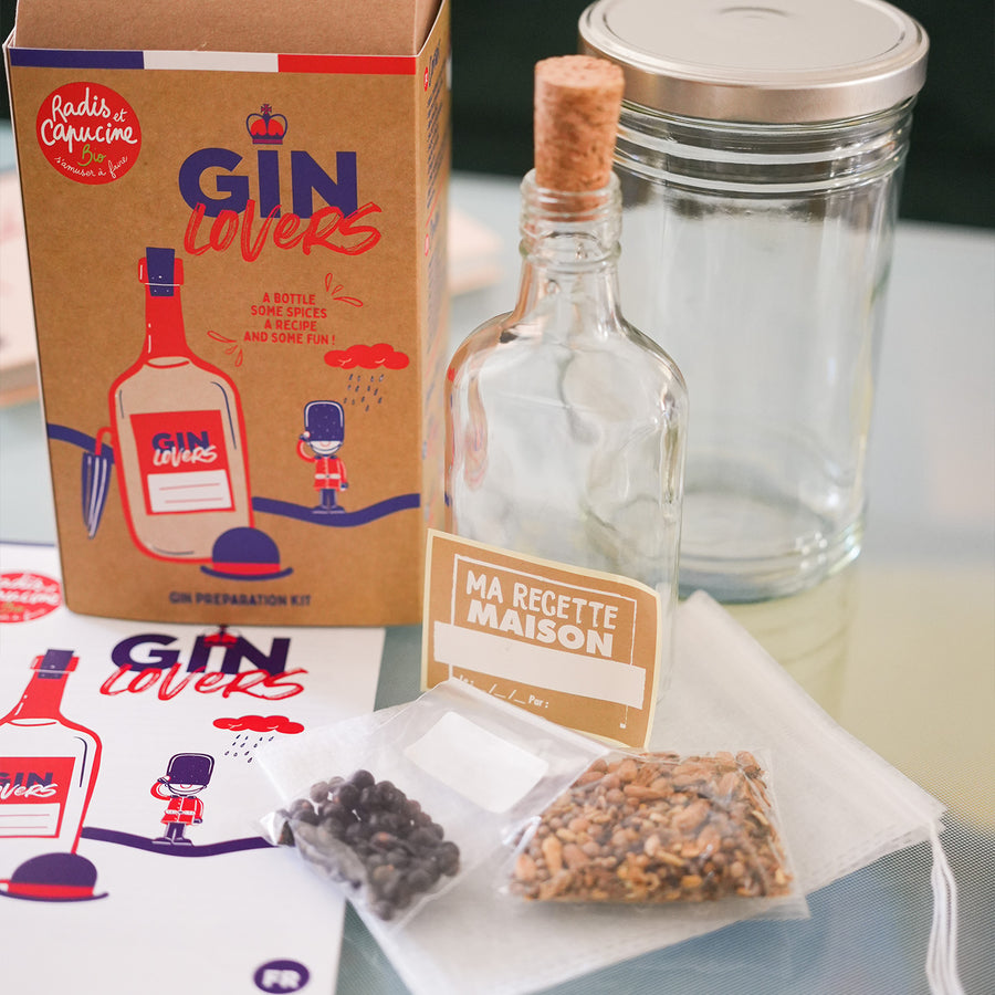 Kit DIY pour gin avec ingrédients et accessoires sur fond clair.