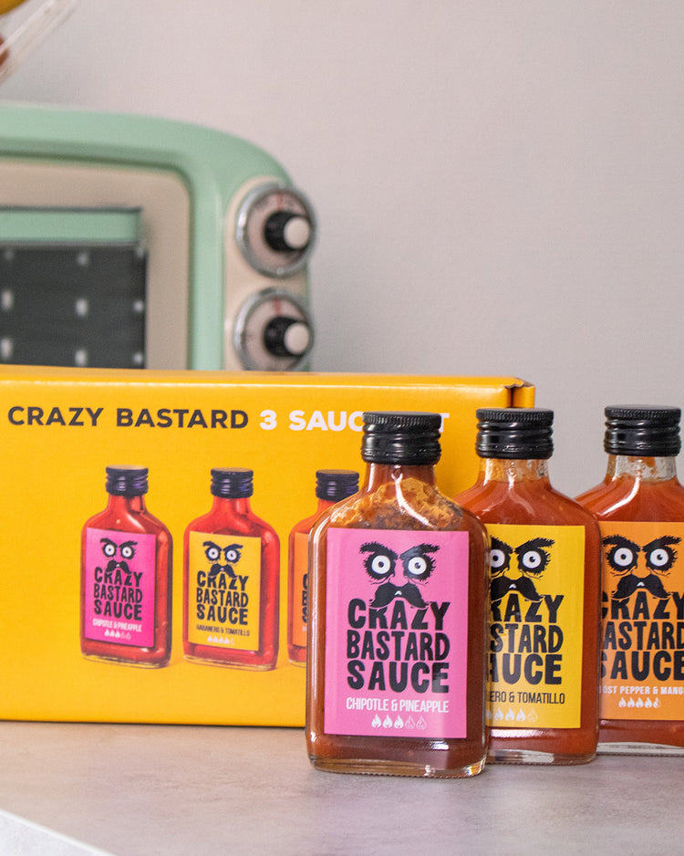 Trois flacons de sauces épicées sur fond blanc