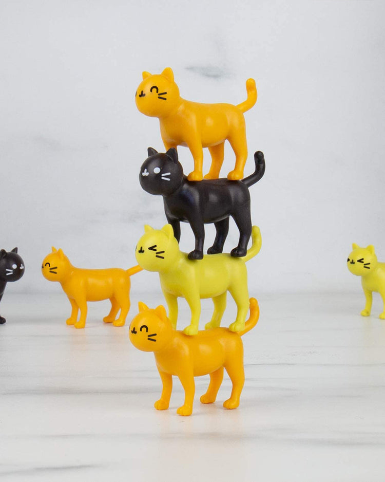 Jeu d'équilibre avec des chats colorés empilés en désordre.