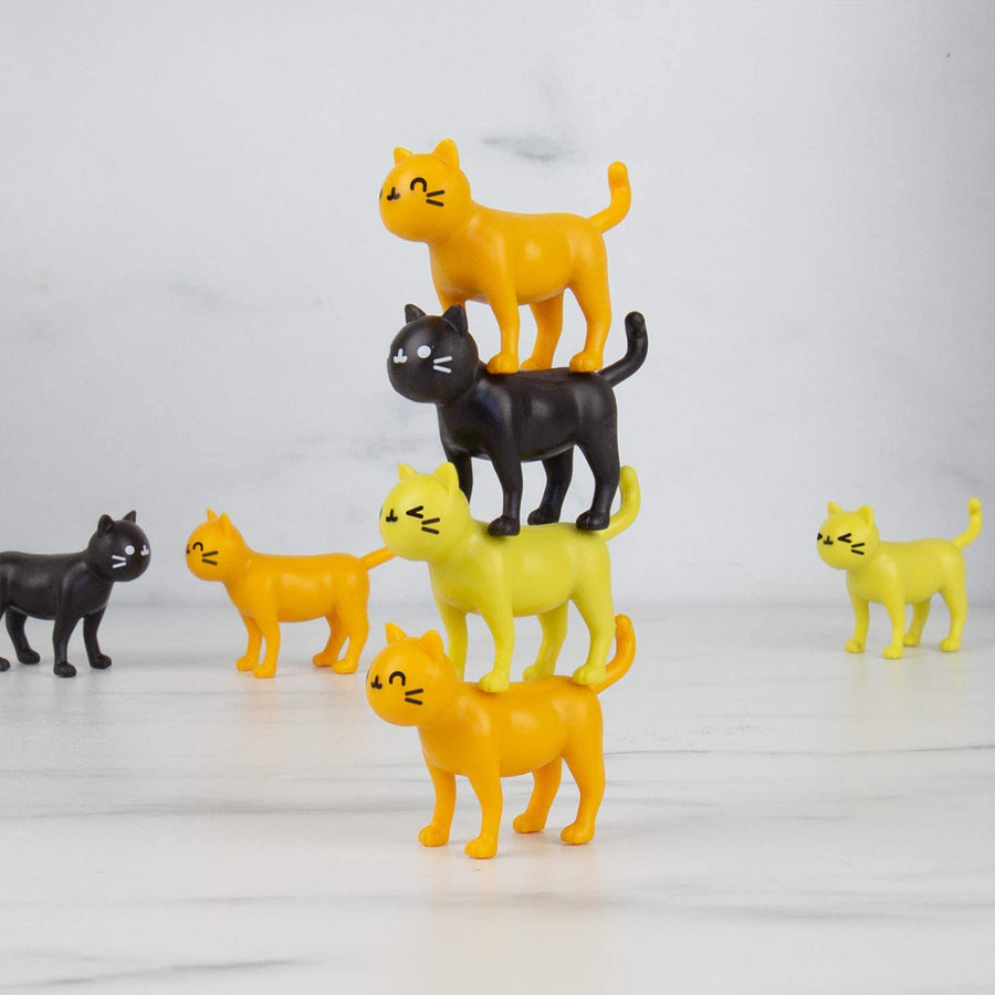 Jeu d'équilibre avec des chats colorés empilés en désordre.