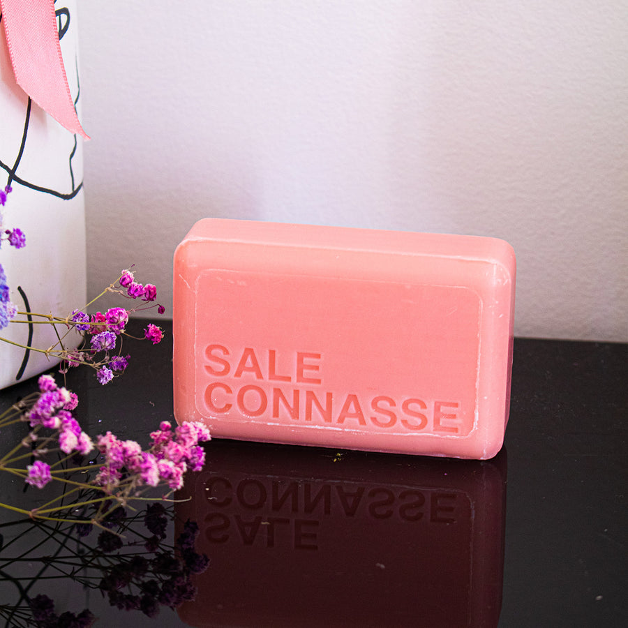 Savon humoristique avec étiquette colorée et motif rose.