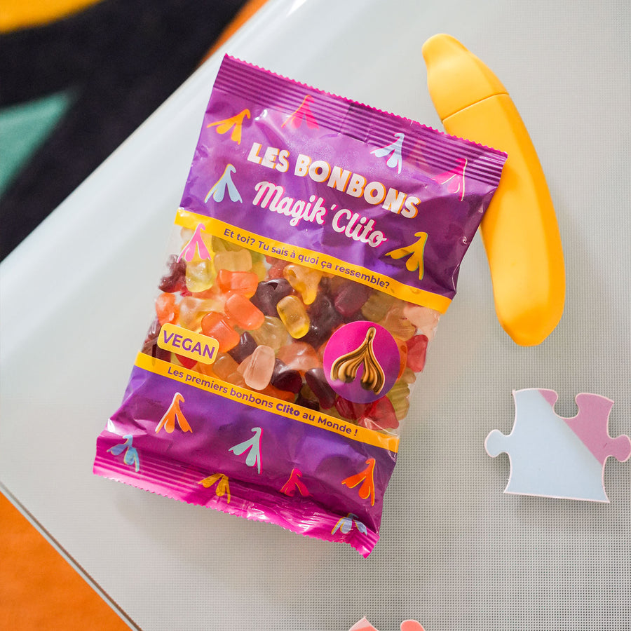 Bonbons en forme de clitoris colorés et sucrés sur fond blanc.