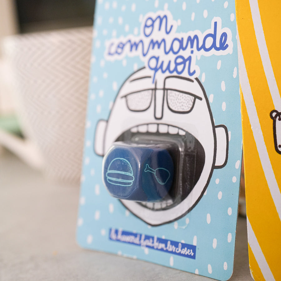 Dé en bois avec inscriptions colorées sur chaque face.