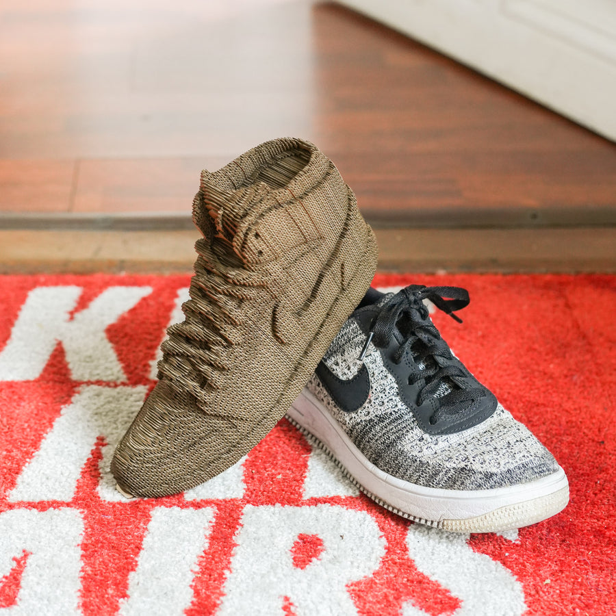 Sculpture en carton de sneakers vue de côté, détails précis.