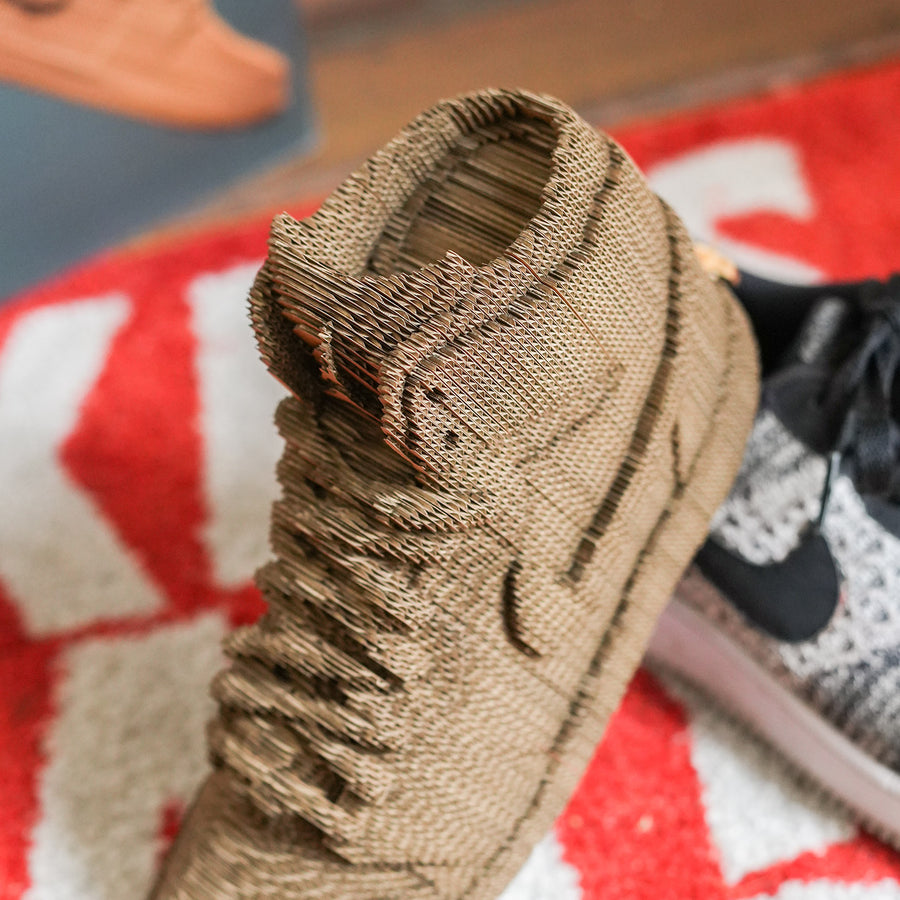 Sculpture en carton DIY de sneakers vue de côté avec détails colorés.