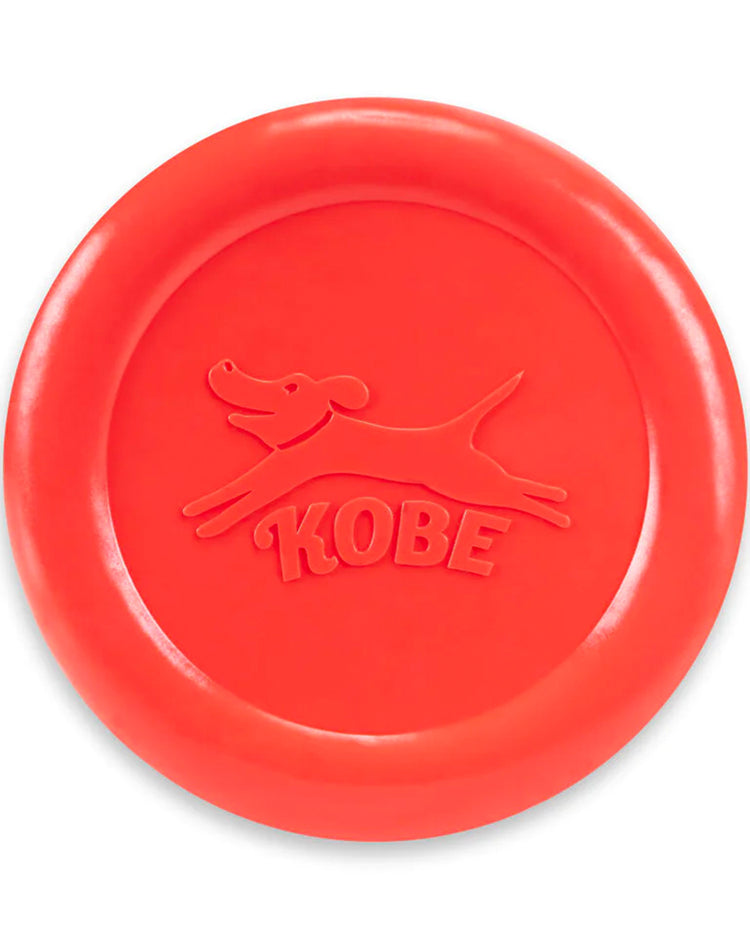Frisbee rouge pour chien avec odeur de bacon, en vol