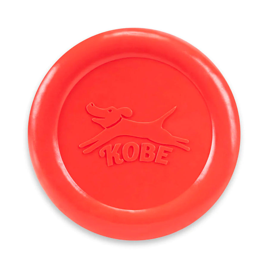 Frisbee rouge pour chien avec odeur de bacon, en vol