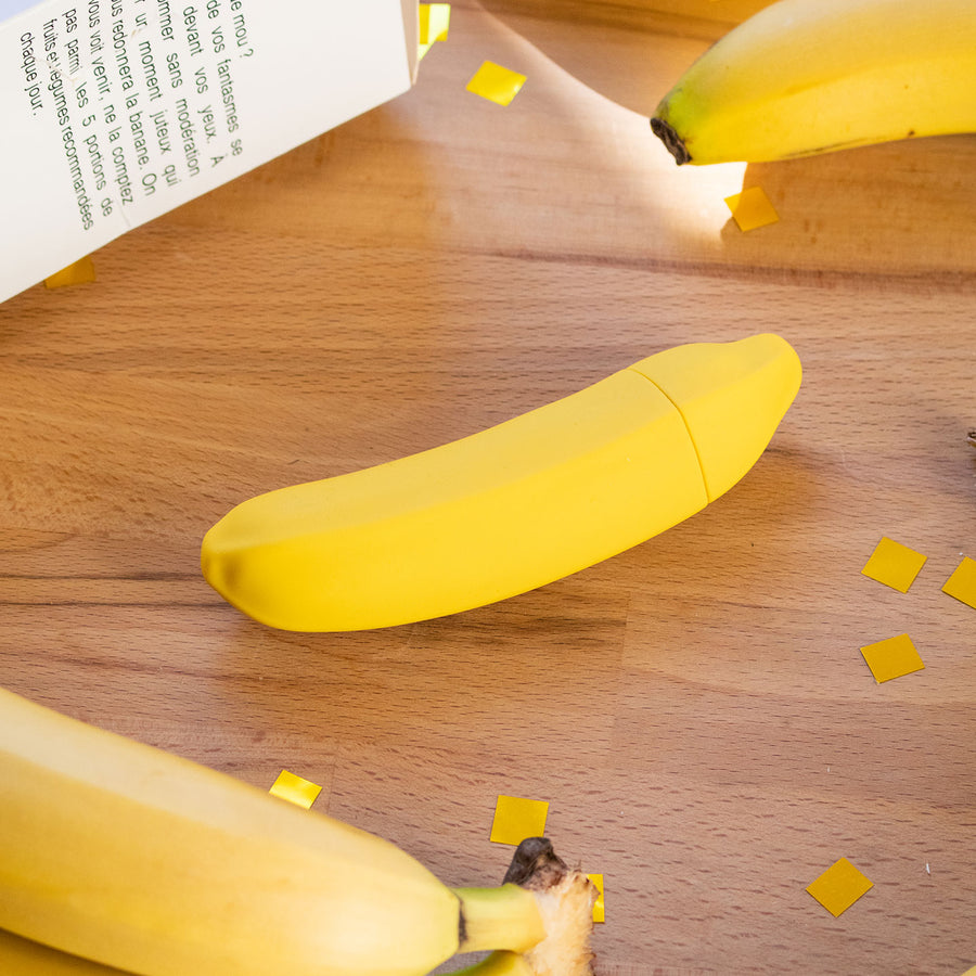 Sextoy vibrant en forme de banane, vue de côté avec texture lisse.