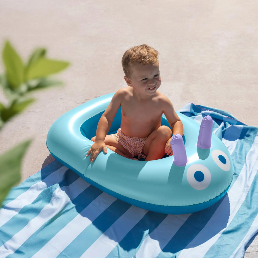 Bouée bateau avec poignées et regard curieux, vue de côté.