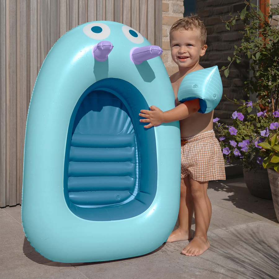 Bouée bateau avec poignées et regard curieux, vue de côté.