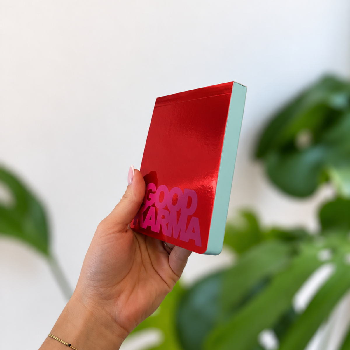 Bloc-notes Good Karma à couverture rouge brillante et tranche turquoise, tenu en
