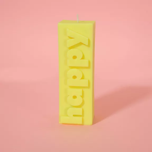 Bougie jaune avec message en relief, ambiance joyeuse