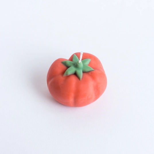 Bougie en forme de tomate avec texture réaliste et brillante.