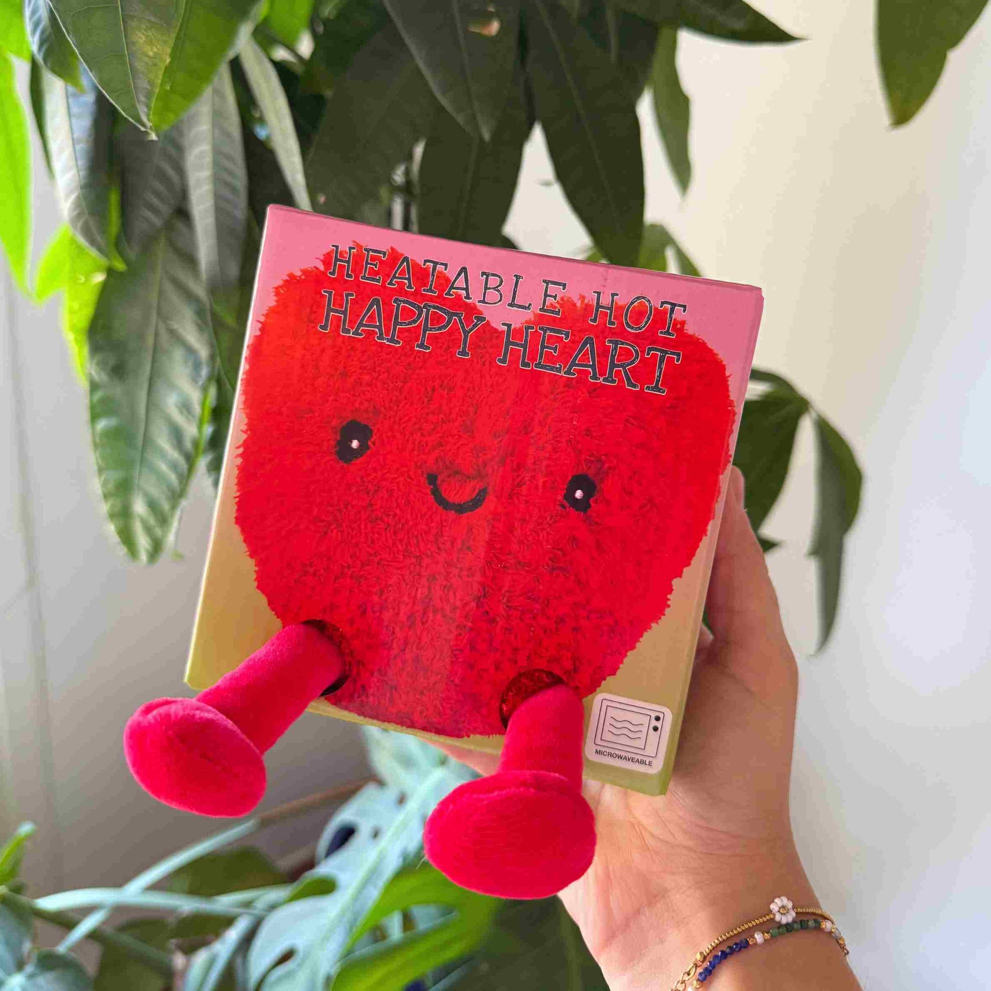 Bouillotte en forme de cœur avec pattes douces et regard affectueux.