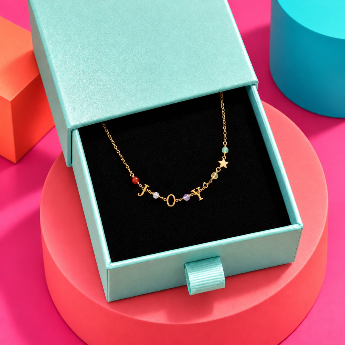 Bracelet doré JOY aux cristaux multicolores, présenté dans un écrin ouvert