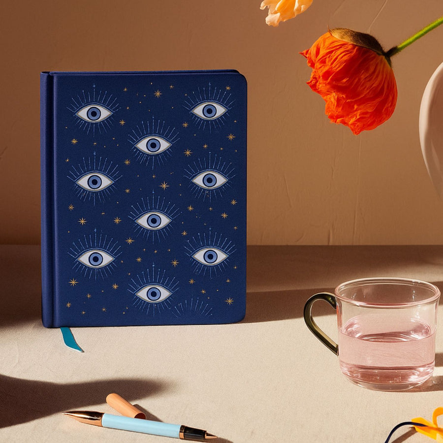 Carnet avec motifs d'yeux sur fond blanc, aspect brillant.