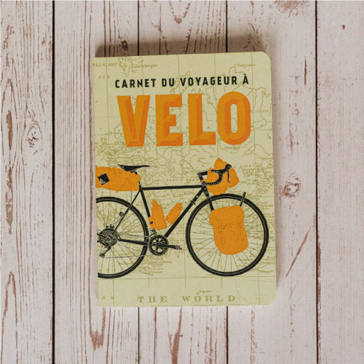 Carnet de voyageur à vélo ouvert sur une page écrite