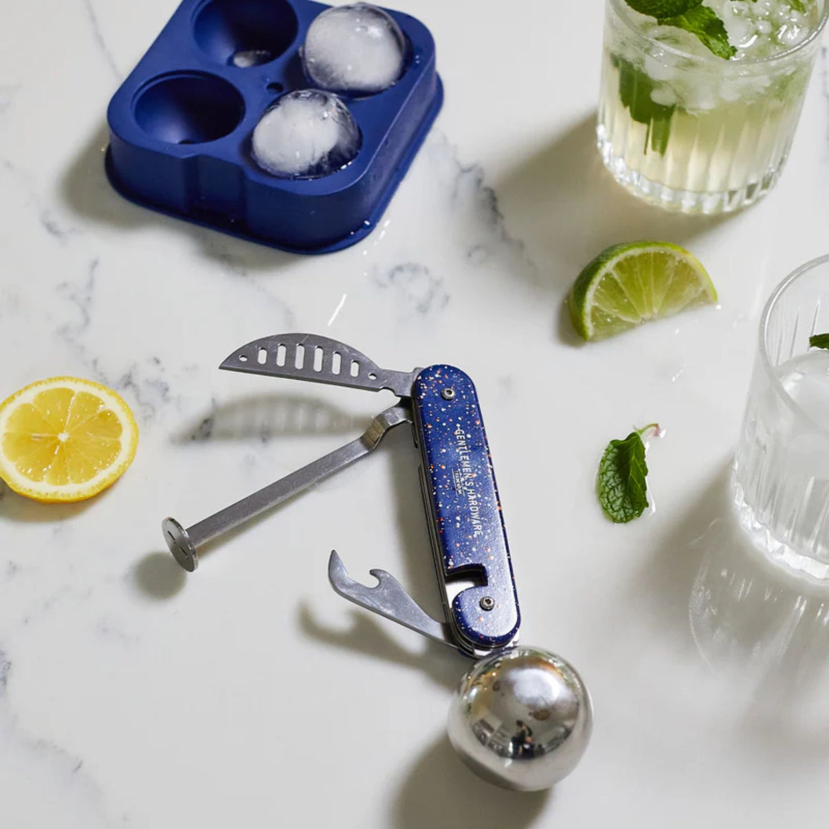 Kit de création de cocktails avec accessoires variés sur fond clair.