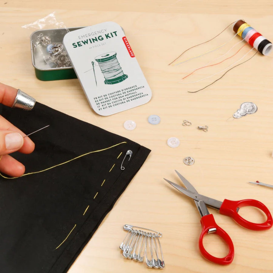 Kit de secours couture avec accessoires variés sur fond neutre