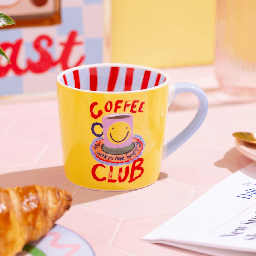 Mug Coffee Club avec message coloré sur fond blanc.