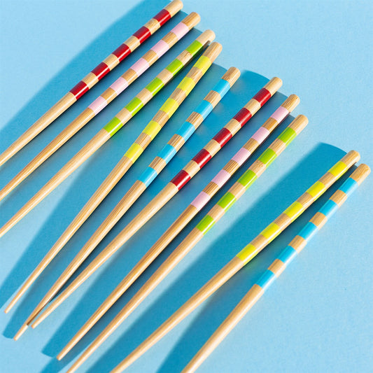 Cinq baguettes en bambou avec motifs rayés colorés.