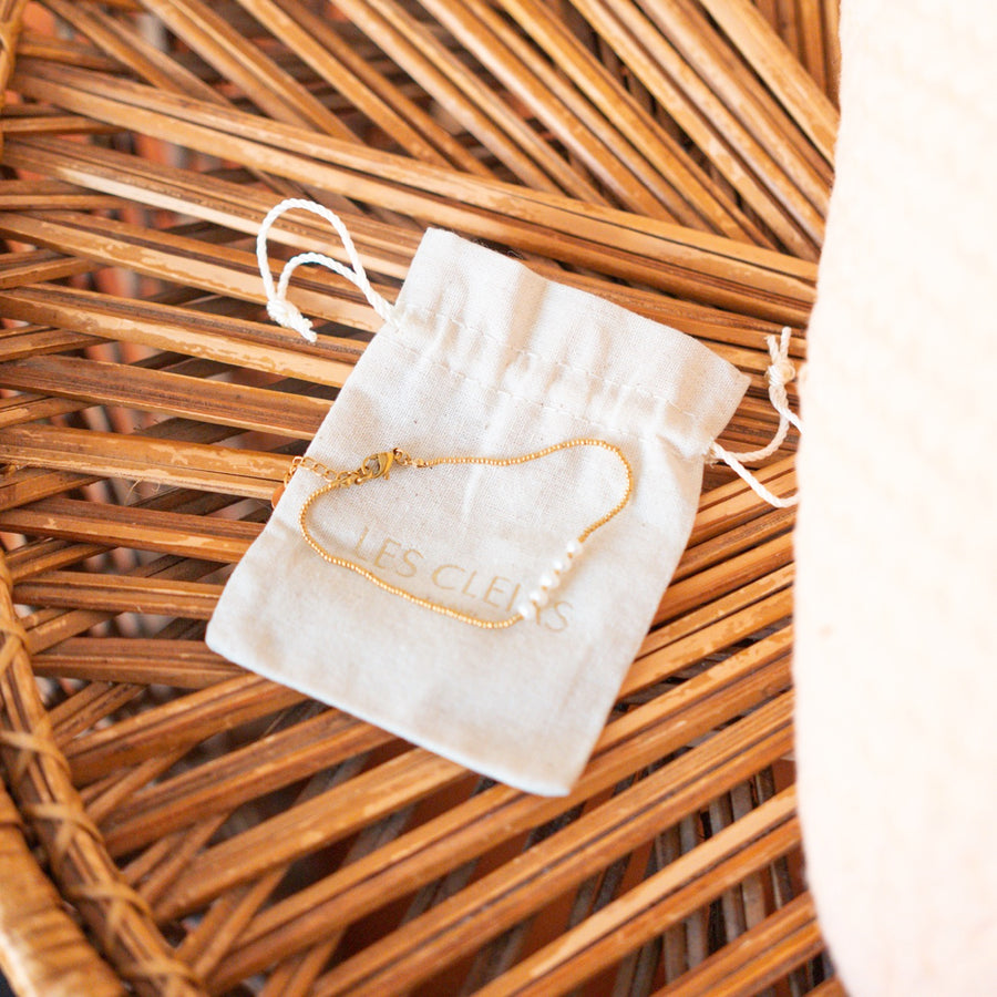 Bracelet délicat avec perles blanches sur chaîne dorée