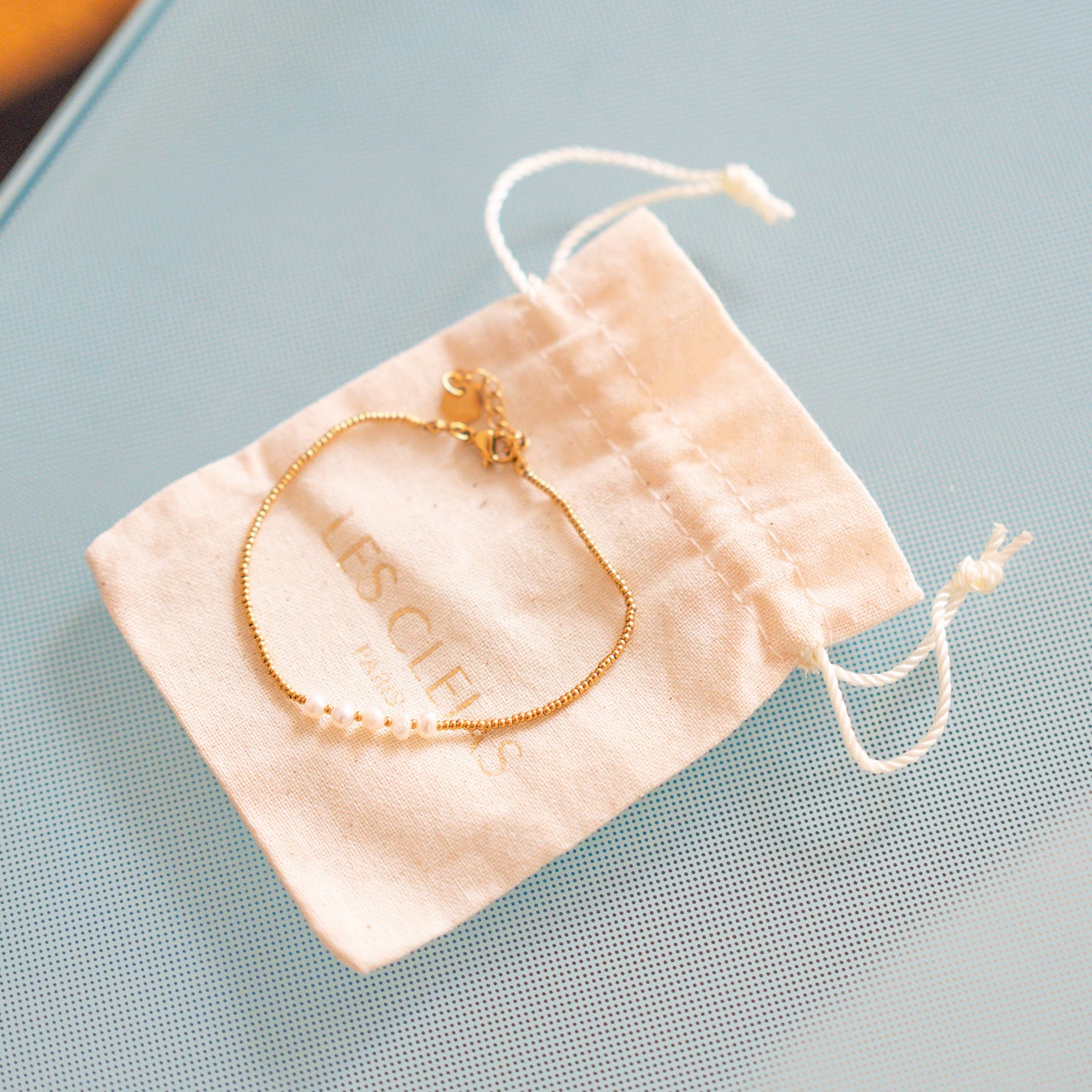 Bracelet délicat avec perles blanches sur chaîne dorée