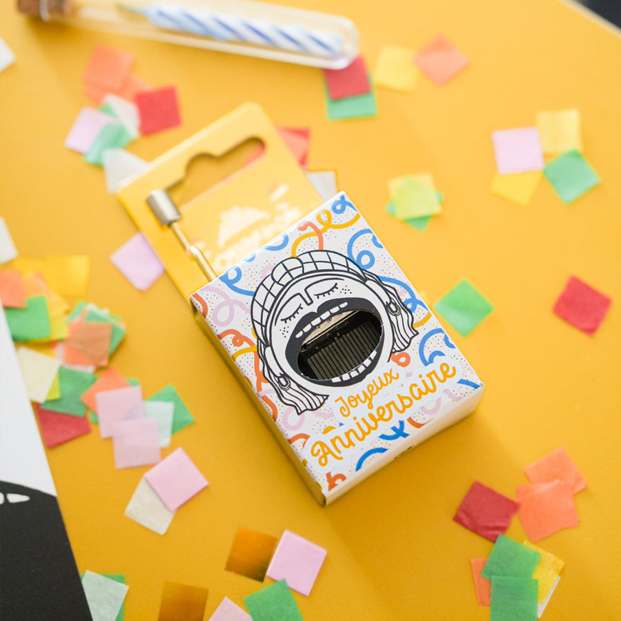 Boîte à musique avec motif de gâteau d'anniversaire coloré.