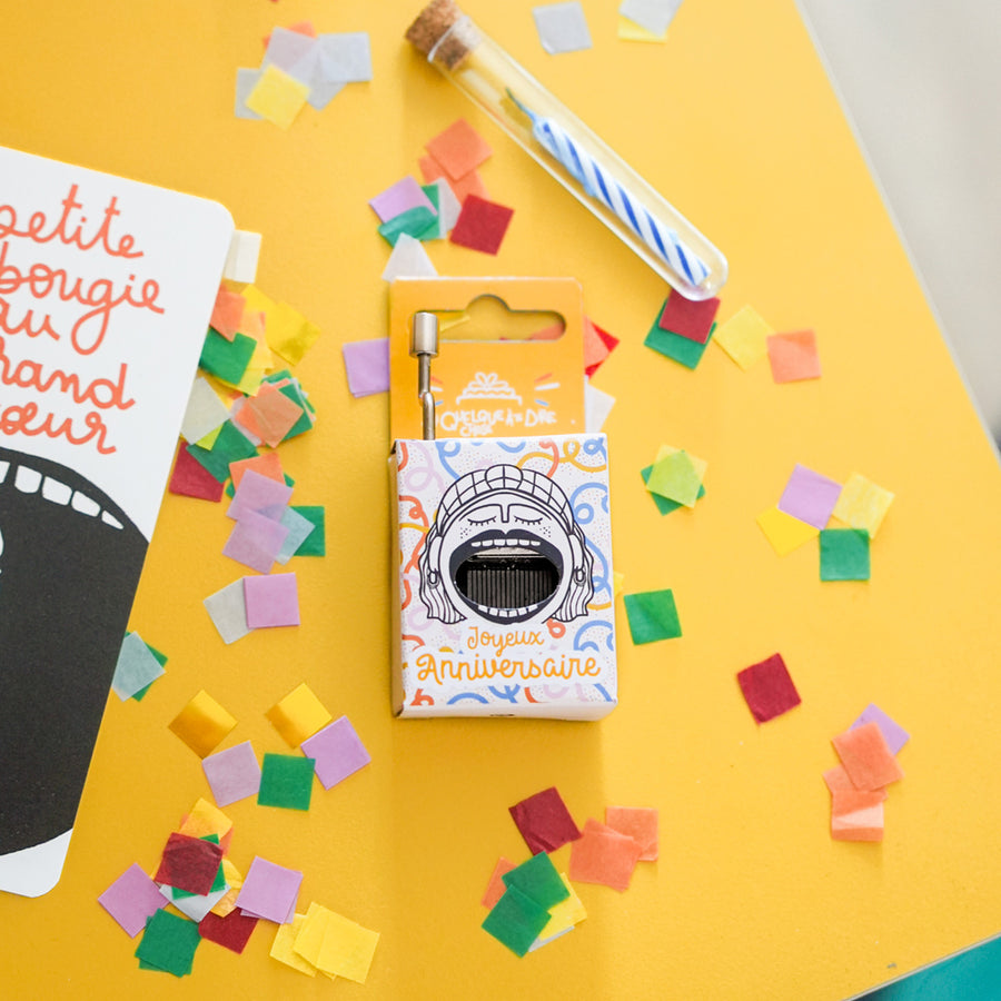 Boîte à musique avec gâteau et bougies colorées en détail