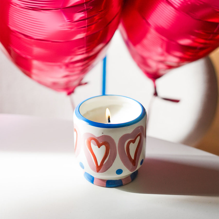 Bougie en céramique peinte à la main avec motifs en cœur.