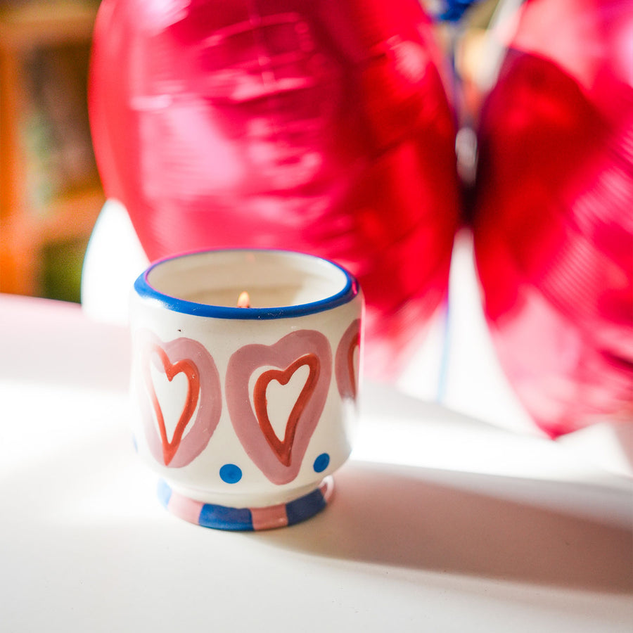 Bougie en céramique peinte à la main avec motifs de cœurs.