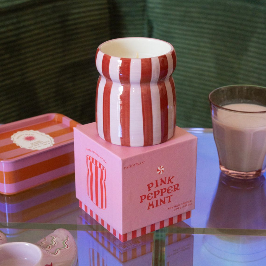 Bougie Color Pop avec rayures colorées et pot en verre.