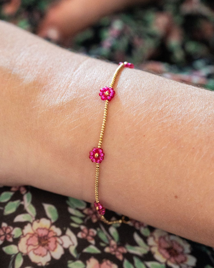 Bracelet avec marguerites roses et détails dorés en gros plan