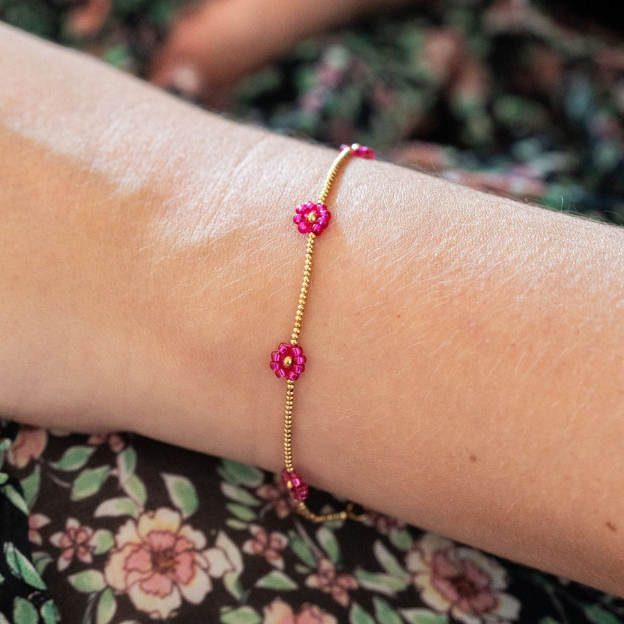 Bracelet avec marguerites roses et détails dorés en gros plan