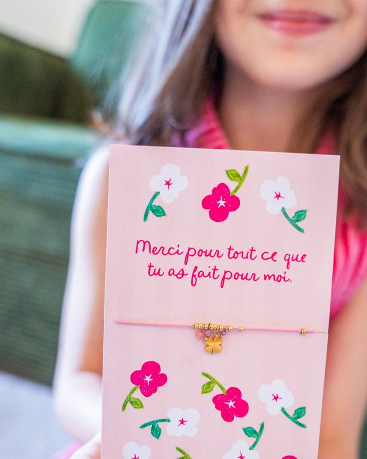 Bracelet doré en trèfle avec carte de remerciement visible