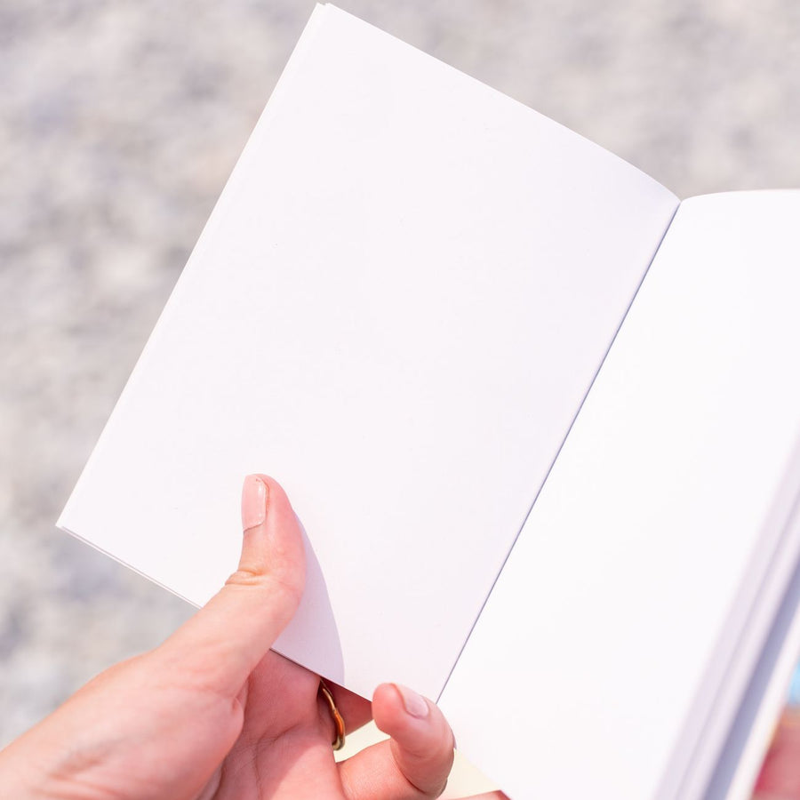 Carnet ouvert montrant ses pages blanches intérieures.