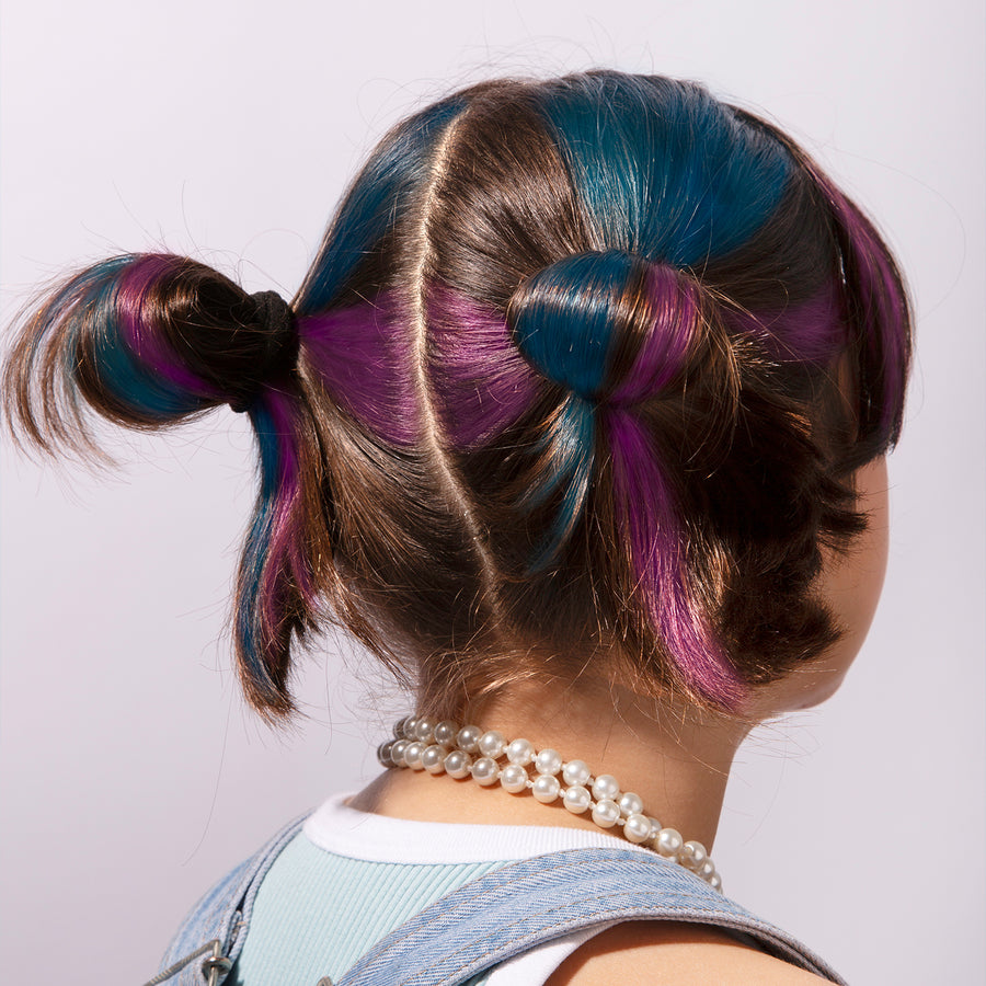 Craies de cheveux colorées en rose, vert et bleu sur fond blanc.