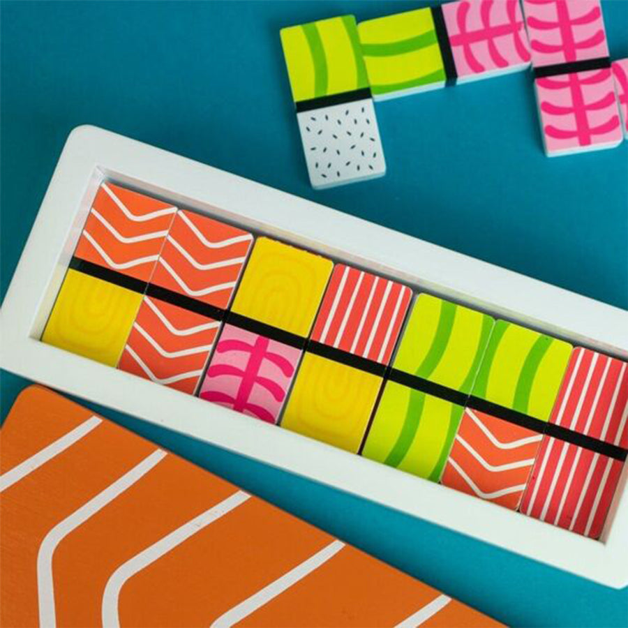 Jeu de dominos en forme de sushis colorés sur fond clair.