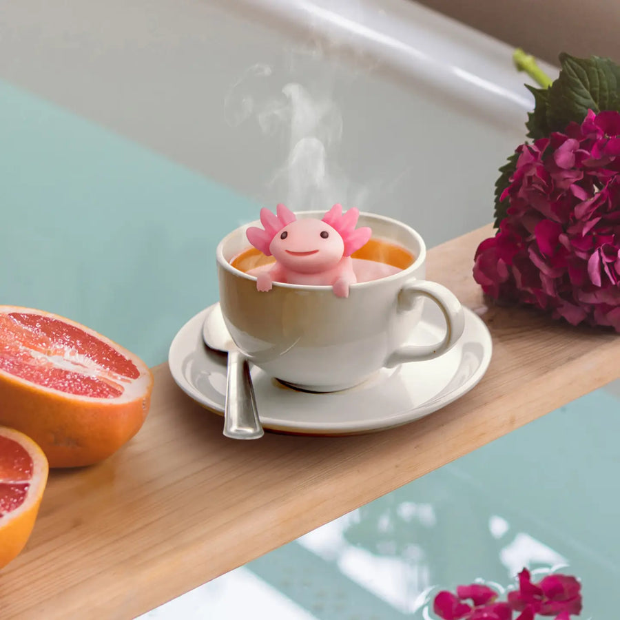 Infuseur à thé axolotl suspendu au bord d'une tasse